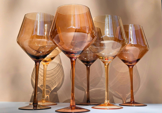 A mixed set of colored glassware in nude tones